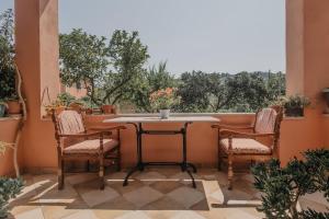a porch with a table and two chairs and a window at Casa Dentraki in Corfu