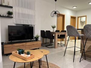 a living room with a television and a table with chairs at Apartman A-lux in Blato