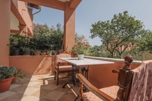 an outdoor patio with a table and chairs and a window at Casa Dentraki in Corfu +20 photos