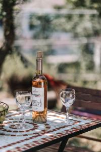 a bottle of wine sitting on a table with two wine glasses at Casa Dentraki in Corfu