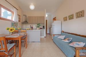 a kitchen and a living room with a blue couch at Casa Dentraki in Corfu