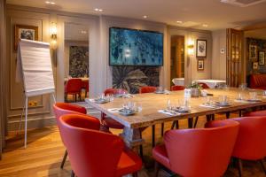 a conference room with a long table and red chairs at Lion & Swan Hotel in Congleton