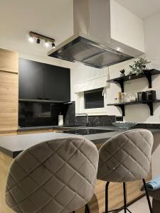 a kitchen with two chairs and a stove top oven at Apartman A-lux in Blato