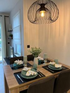 a dining room table with plates and a chandelier at Apartman A-lux in Blato