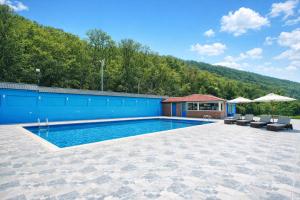 a swimming pool with chairs and a building at Colorato Quba in Qırmızı Qǝsǝbǝ +22 photos