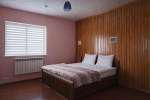 a bedroom with a bed with a wooden wall at Colorato Quba in Qırmızı Qǝsǝbǝ