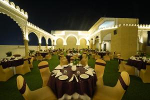 a banquet hall with tables and chairs in a building at The Royal Bihar in Patna