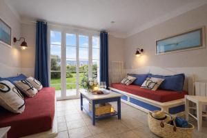 a living room with two beds and a window at LocaLise - Maison E4 au Guilvinec - A 20m de la mer avec jardin et piscine - Tout à pied, plages, port, centre, commerces, marché - Wifi inclus - Linge de lit inclus - Animaux bienvenus in Le Guilvinec