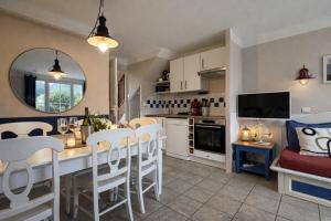 a kitchen and dining room with a table and chairs at LocaLise - Maison E4 au Guilvinec - A 20m de la mer avec jardin et piscine - Tout à pied, plages, port, centre, commerces, marché - Wifi inclus - Linge de lit inclus - Animaux bienvenus in Le Guilvinec