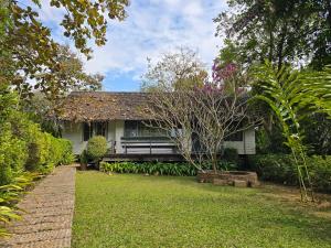 a white house with a bench in the yard at Vanilla hill (hill lodge) in Ban Muang Ha