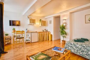 a living room with a bed and a kitchen at Green Haven - Joli studio - Centre Ville de Caen in Caen