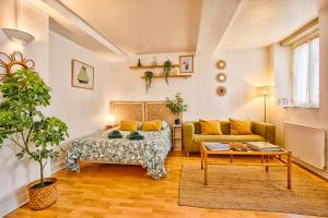 a living room with a bed and a couch at Green Haven - Joli studio - Centre Ville de Caen in Caen +5 photos