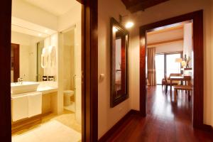 a bathroom with a sink and a toilet and a mirror at Pousada Convento de Tavira in Tavira