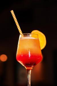 a drink with an orange slice in a glass at Complexo Palmeiras Bilene in Vila Praia Do Bilene