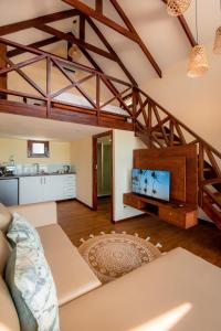 a living room with a couch and a tv at Complexo Palmeiras Bilene in Vila Praia Do Bilene