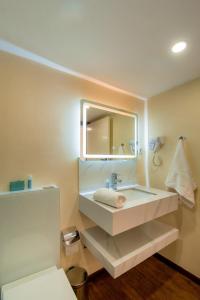 a bathroom with a sink and a mirror at Complexo Palmeiras Bilene in Vila Praia Do Bilene +12 photos