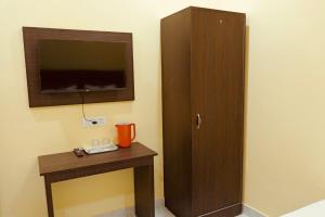 a room with a cabinet and a table with a television at Hotel Ramkrishna Stay in Khajurāho