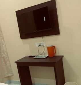 a wooden table with a tv on a wall at Hotel Ramkrishna Stay in Khajurāho