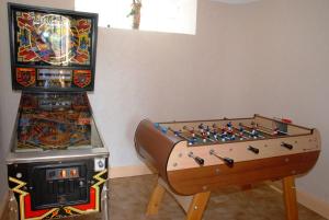 a game room with a foosball table and a pinball machine at Le Logis du Port in Domme