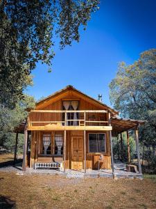 a large wooden house in the middle of a field at Cabaña Santa Amelia Antuco Pet Friendly in Peluca