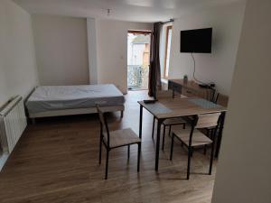 a room with a bed and a table and chairs at studio confort a prix doux in Selles-sur-Cher