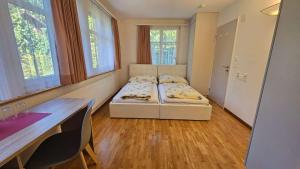 a room with two beds and a table and windows at Marienburg Castle in Wikon