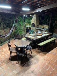a patio with a table and chairs and a grill at Chalé Gravatá 2022 in Gravatá