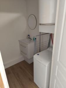 a laundry room with a washer and dryer and a mirror at studio confort a prix doux in Selles-sur-Cher