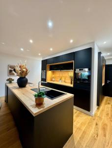 a kitchen with black cabinets and a counter top at La Maison Contemporaine, Luxe et Elégance aux portes de Rennes in Cesson-Sévigné +9 photos