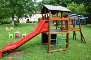 a playground with a red slide and a gazebo at Le Logis du Port in Domme