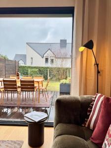 a living room with a couch and a table and chairs at La Maison Contemporaine, Luxe et Elégance aux portes de Rennes in Cesson-Sévigné