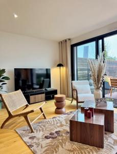 a living room with furniture and a large window at La Maison Contemporaine, Luxe et Elégance aux portes de Rennes in Cesson-Sévigné