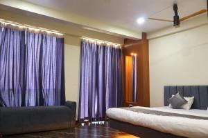 a bedroom with purple curtains and a bed at Hotel Maharana Inn in Sehore