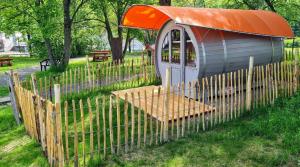 a small train in a park with a fence at Schlaffässer am Haus der Schmetterlinge in Uslar