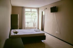 a room with a bed and a window in it at Kitnet em Betim no centro in Betim