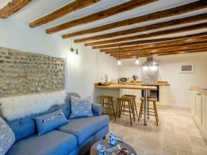 a living room with a blue couch and a kitchen at 1 Bed in Holt oc-78233 in Cley next the Sea
