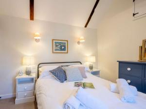 a bedroom with a bed with white sheets and blue pillows at 1 Bed in Holt oc-78233 in Cley next the Sea