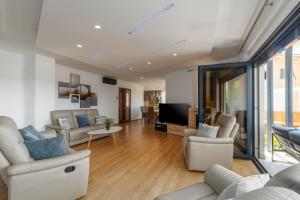 a living room with white furniture and a flat screen tv at Villa Bellavista in Medulin