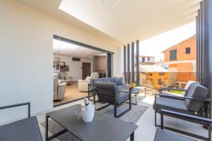 a living room with a balcony with chairs and a table at Villa Bellavista in Medulin
