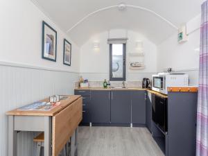 a kitchen with blue cabinets and a counter top at Shepherds Hut - Uk49096 in Inchnadamph