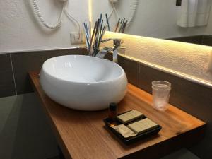 a white sink on a wooden counter in a bathroom at Villa Kuky in Santa Teresa Gallura +37 photos