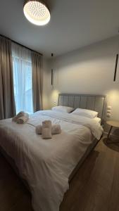 a bedroom with a large white bed with towels on it at By The River Stay in Florina