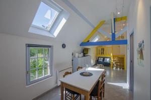 a kitchen and dining room with a table and windows at Le paradis des ecureuils in Saint-Thibault