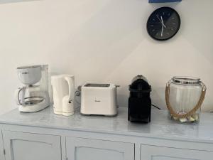 a counter top with appliances on it with a clock at Le paradis des ecureuils in Saint-Thibault