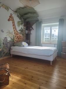 a bedroom with a bed with a mural of a giraffe at Maison de Coton Ty Koton in Plourivo