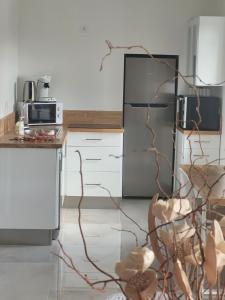 a kitchen with a stainless steel refrigerator and white cabinets at Maison de Coton Ty Koton in Plourivo
