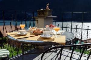 a table with a plate of food and glasses of orange juice at Albergo Diffuso Ca' Spiga in Laglio