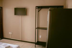 a room with a bed and a mirror and a lamp at Kitnet em Betim no centro in Betim +19 photos