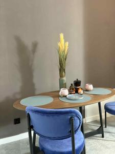 a wooden table with two plates and a vase at Apartamenty Staszica in Bielsko-Biała +30 photos