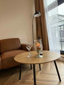 a coffee table with two glasses and a candle on it at Apartamenty Staszica in Bielsko-Biała